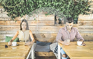 Fashion couple in disinterest moment ignoring each other using phone