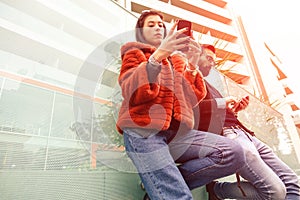 Fashion couple looking their smarphones - Hipster couple in sad moment ignoring each other using mobile phones - Travel and