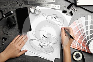 Fashion designer drawing shoes at table, top view