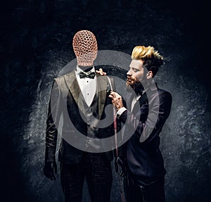 A fashion designer with expressive style working with custom made men`s suit in a dark tailor studio