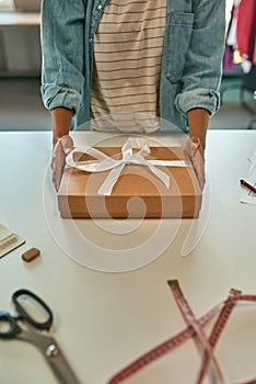 Fashion designer holding gift box with new clothes