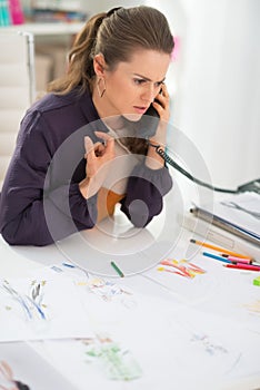 Fashion designer in office talking phone