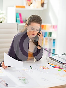 Fashion designer in office talking phone