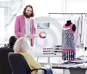 Fashion designer showing colleagues the color palette for the new collection