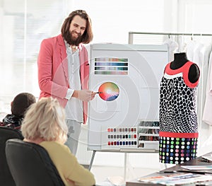 Fashion designer showing colleagues the color palette for the new collection
