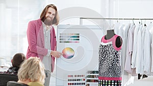 Fashion designer showing colleagues the color palette for the new collection