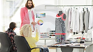 Fashion designer showing colleagues the color palette for the new collection