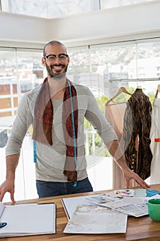 Fashion designer standing at table in office