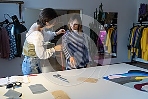 Fashion designer woman takes measurements with measuring tape of client before tailoring clothes