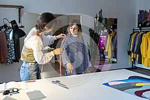 Fashion designer woman takes measurements with measuring tape of client before tailoring clothes