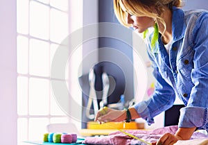 Fashion designer woman working on her designs in the studio