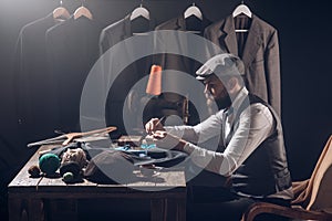 Fashion designer at work. business dress code. Handmade. sewing mechanization. Bearded man tailor sewing jacket. retro