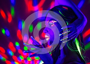 Fashion disco woman. Dancing model in neon light, portrait of beauty girl with fluorescent makeup photo