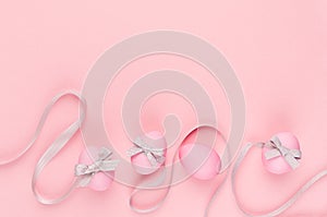 Fashion easter background - pink eggs with grey ribbon quaint stripes as border on pastel pink color.