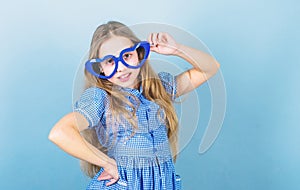 Fashion eyewear. Kid girl heart shaped eyeglasses. Girl adorable smiling face fall in love. Child charming smile blue