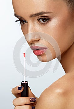 Fashion Female Model With Beauty Face Applying Lip Balm On Lips