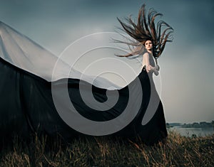 Fashion female model with long blowing hair outdoor.