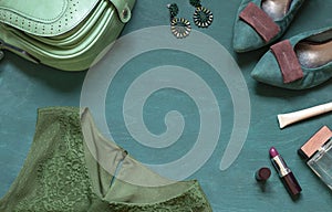 Fashion flat lay on the wooden turquoise background with cosmetics, shoes and dress.