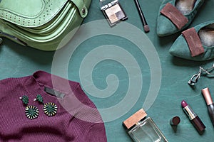 Fashion flat lay on the wooden turquoise background with cosmetics, shoes and dress.