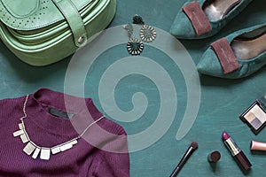 Fashion flat lay on the wooden turquoise background with cosmetics, shoes and dress.