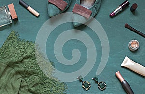 Fashion flat lay on the wooden turquoise background with cosmetics, shoes and dress. Top view concept frame.