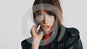 Fashion girl with bob hair and red lips looking serious over white background. Professional model posing in studio