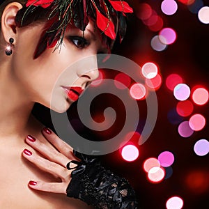 Fashion girl with feathers. Glamour young woman with red lipstick and lace gloves over Bokeh background. Portrait. Evening Makeup