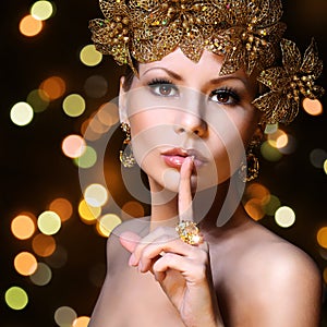 Fashion Girl with Gold Jewelries over bokeh background. Beauty