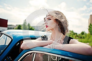 Fashion girl model with bright makeup in retro style and vintage car