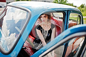 Fashion girl model with bright makeup in retro style and vintage car