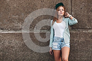 Fashion girl posing near concrete wall