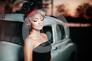 Fashion girl in retro style posing near old car