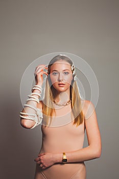 Fashion girl with rope strap on her hand at grey background