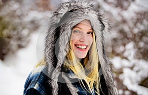 Fashion girl in warm clothing in winter park. Closeup portrait of smiling woman in winter day. Beautiful girl in plaid