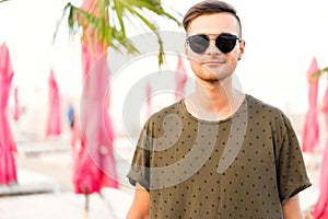 Fashion guy on the beach walking in sunglasses