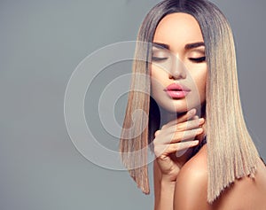 Fashion hairstyle. Ombre dyed hair. Beauty Model girl with perfect healthy hair and beautiful makeup posing in studio