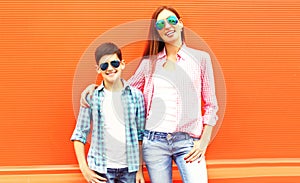 Fashion happy mother with son teenager in a sunglasses, checkered shirts