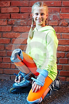 Fashion happy smiling hipster cool girl in colorful clothes with roller skates having fun outdoors