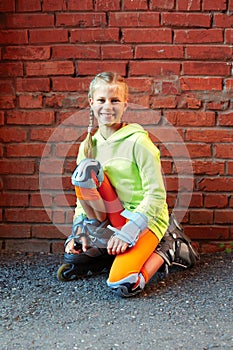 Fashion happy smiling hipster cool girl in colorful clothes with roller skates having fun outdoors