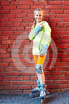 Fashion happy smiling hipster cool girl in colorful clothes with roller skates having fun outdoors