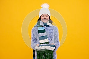 Fashion happy young woman in knitted hat and sweater having fun over colorful blue background. Happy girl face, positive