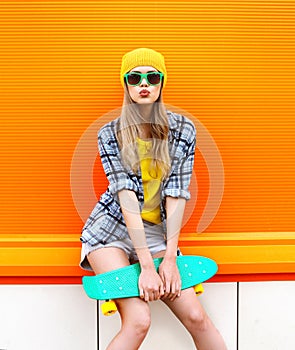 Fashion hipster cool girl in sunglasses and colorful clothes
