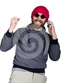 Fashion hipster cool man in sunglasses and colorful clothes. calls on a phone and smiling. He raised his hand up