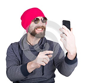 Fashion hipster cool man in sunglasses and colorful clothes holding a phone in front of him and pictures of themselves