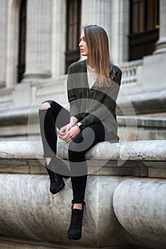 Fashion hipster portrait of young elegant woman outdoor in sweater and jeans