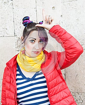 Fashion hipster woman with colorful hair doing looser gesture