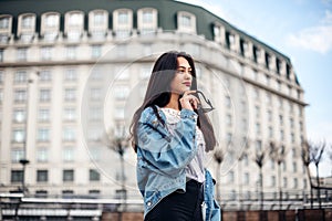 Fashion hipster woman posing outdoor.portrait of a young sexy brunette hipster girl. dressed in a stylish large denim jacket