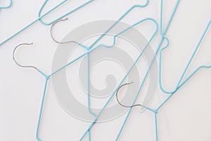 Fashion industry mockup on white background with blue hangers. Minimal concept, Top view. Flat lay composition