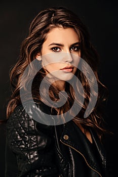Beautiful sexy woman in elegant leather jacket posing in studio photo