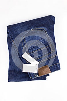 Fashion jeans button. Blue jeans lying on white background with price tag. Copy space. Clothing, online store concepts